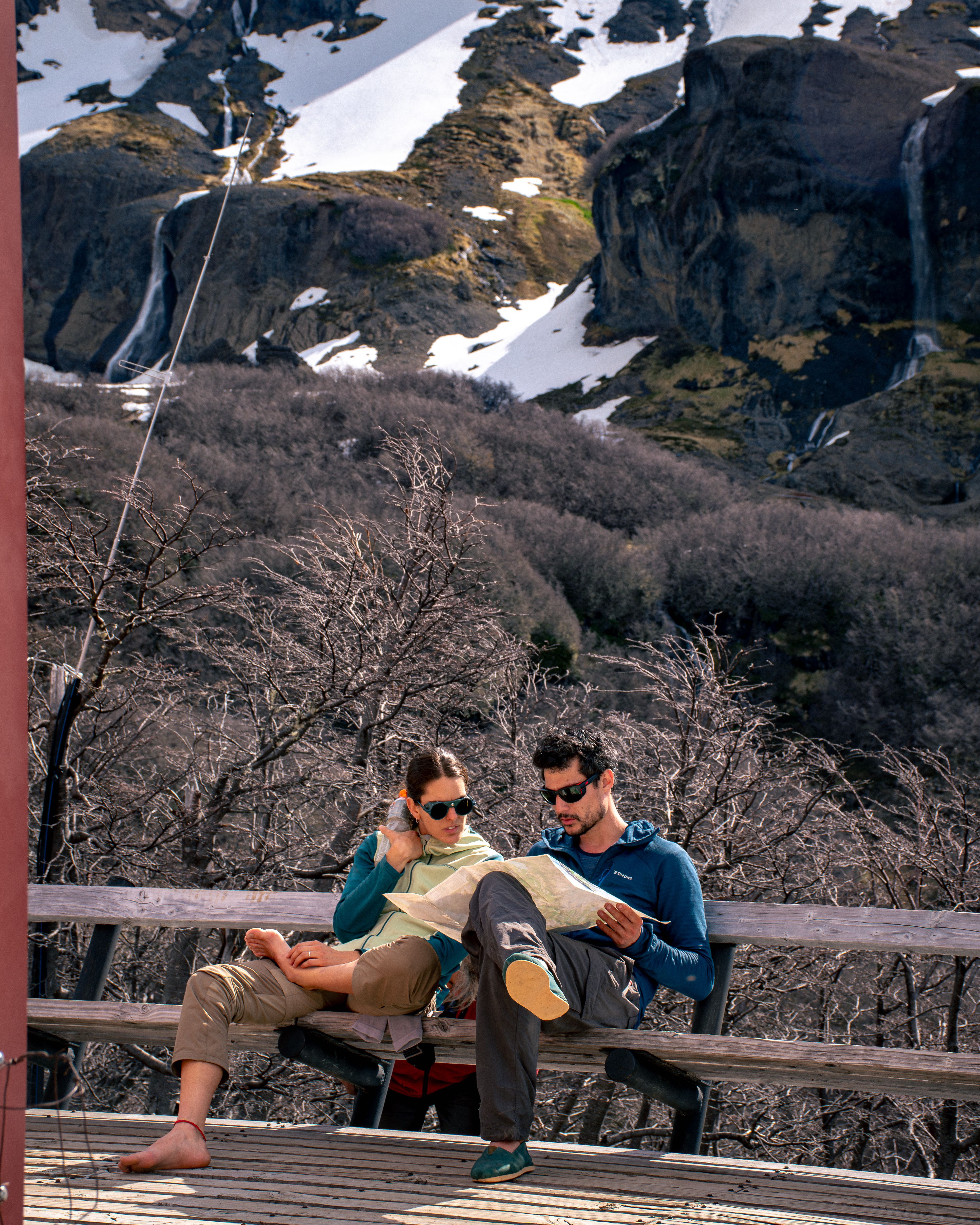 Couple relaxing with a map outdoors in scenic Bariloche, Argentina.