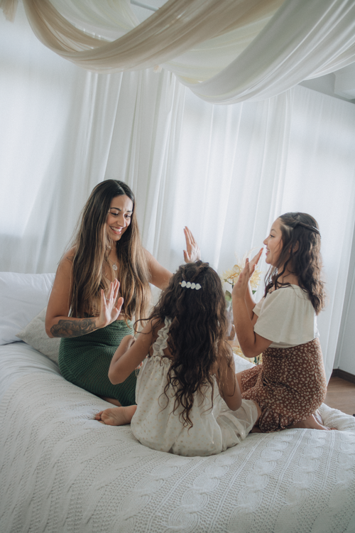 Free Mother and daughters enjoy quality time in a cozy bedroom setting, sharing laughter and play. Stock Photo