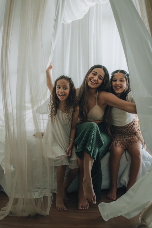 Free Smiling mother with daughters enjoying a cozy indoor moment, filled with love and joy. Stock Photo