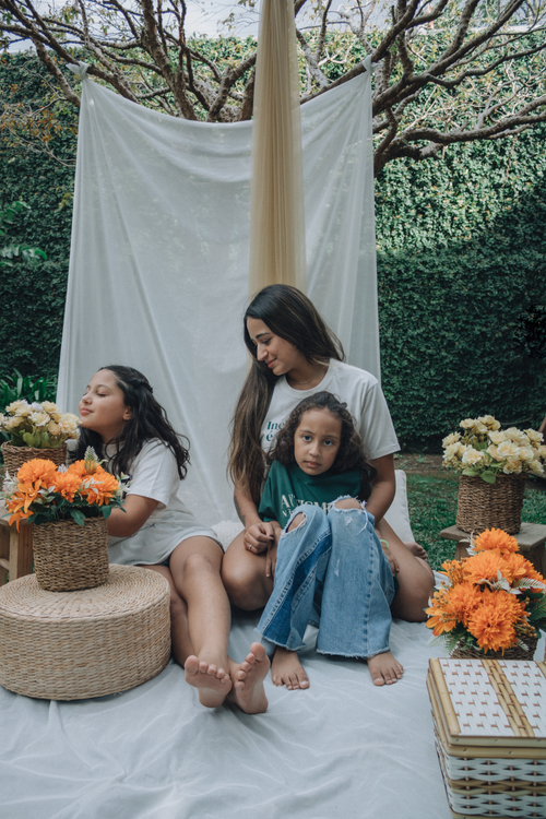 Free Family enjoying a relaxed outdoor setting with flowers and bohemian decor. Stock Photo