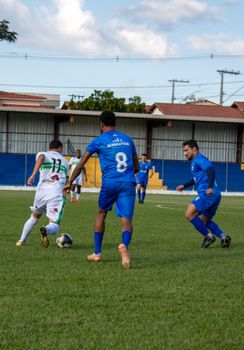 Exciting amateur soccer match with players in blue and white jerseys competing outdoors.
