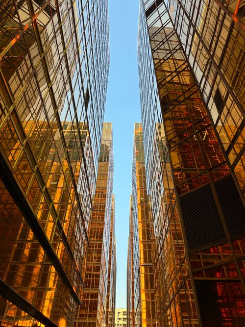 Free Dramatic view of sunlit skyscrapers reflecting gold tones in Kowloon, Hong Kong. Stock Photo