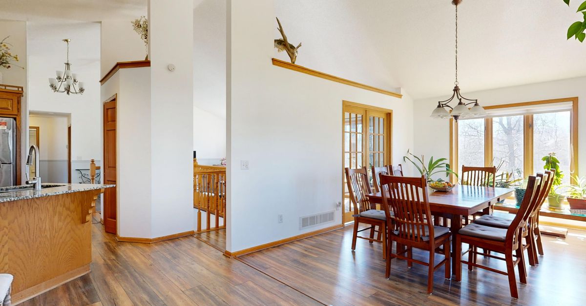 Bright dining room with large windows and elegant wooden furniture in a modern home.