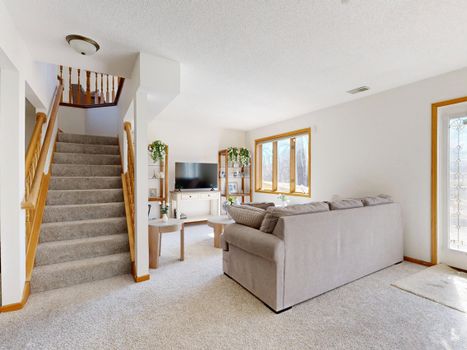 Inviting living room with cozy sofa and natural light through large windows.