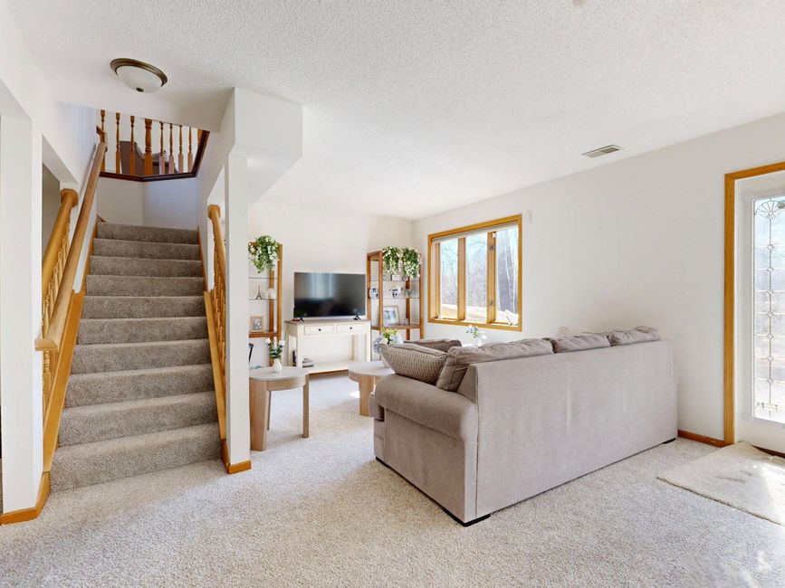 Inviting living room with cozy sofa and natural light through large windows.