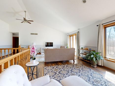 Modern living room with comfortable seating and natural light through large windows.