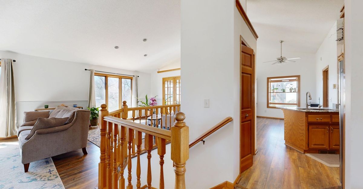 Spacious living room with natural light and view of modern kitchen.