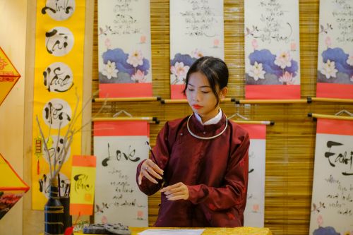 Free Woman practicing calligraphy surrounded by Vietnamese art in Hue, Vietnam. Stock Photo