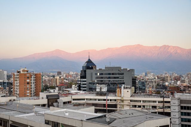 Stunning view of Santiago's skyline with the Andes during sunset, showcasing urban life in Chile.