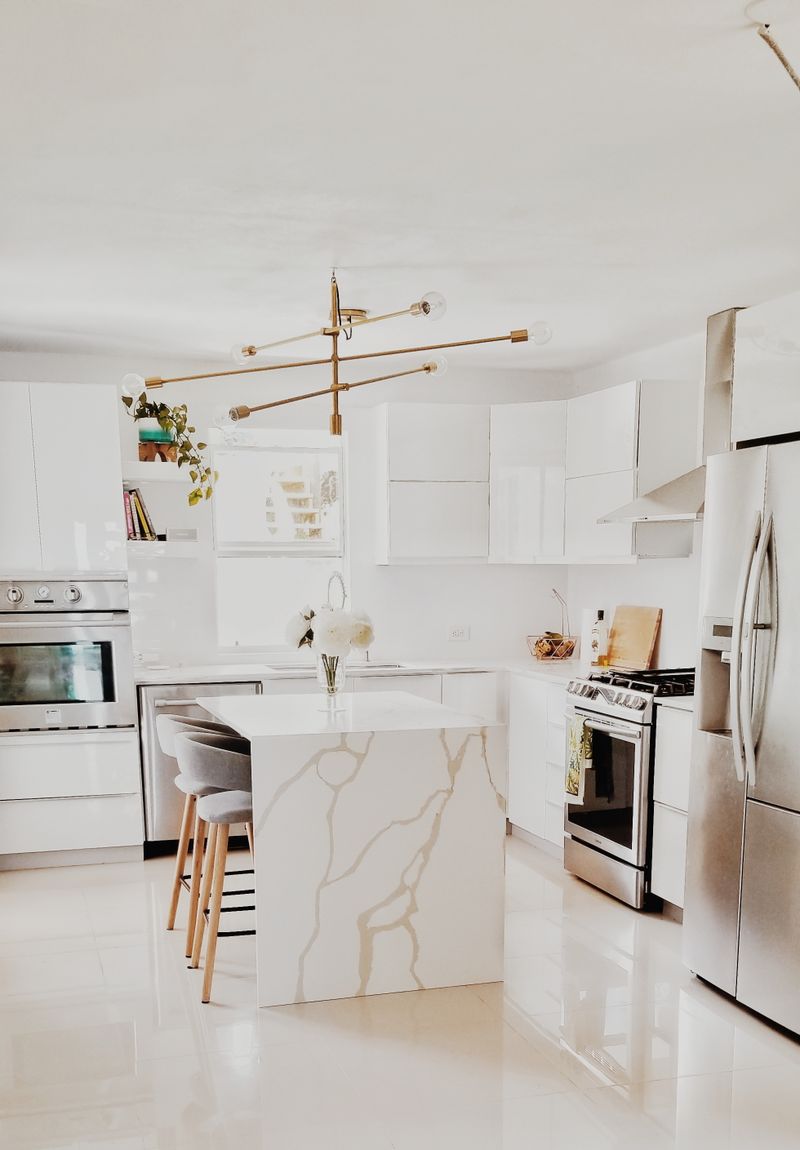 Cocina renovada con muebles blancos y electrodomésticos modernos