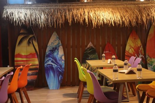 Colorful surfboards and chairs add a tropical flair to this indoor cafe setting.
