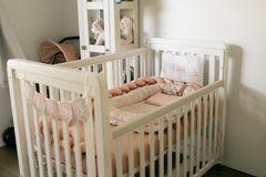 A warm and inviting baby nursery featuring a white crib adorned with plush blankets and stuffed toys, exuding comfort.