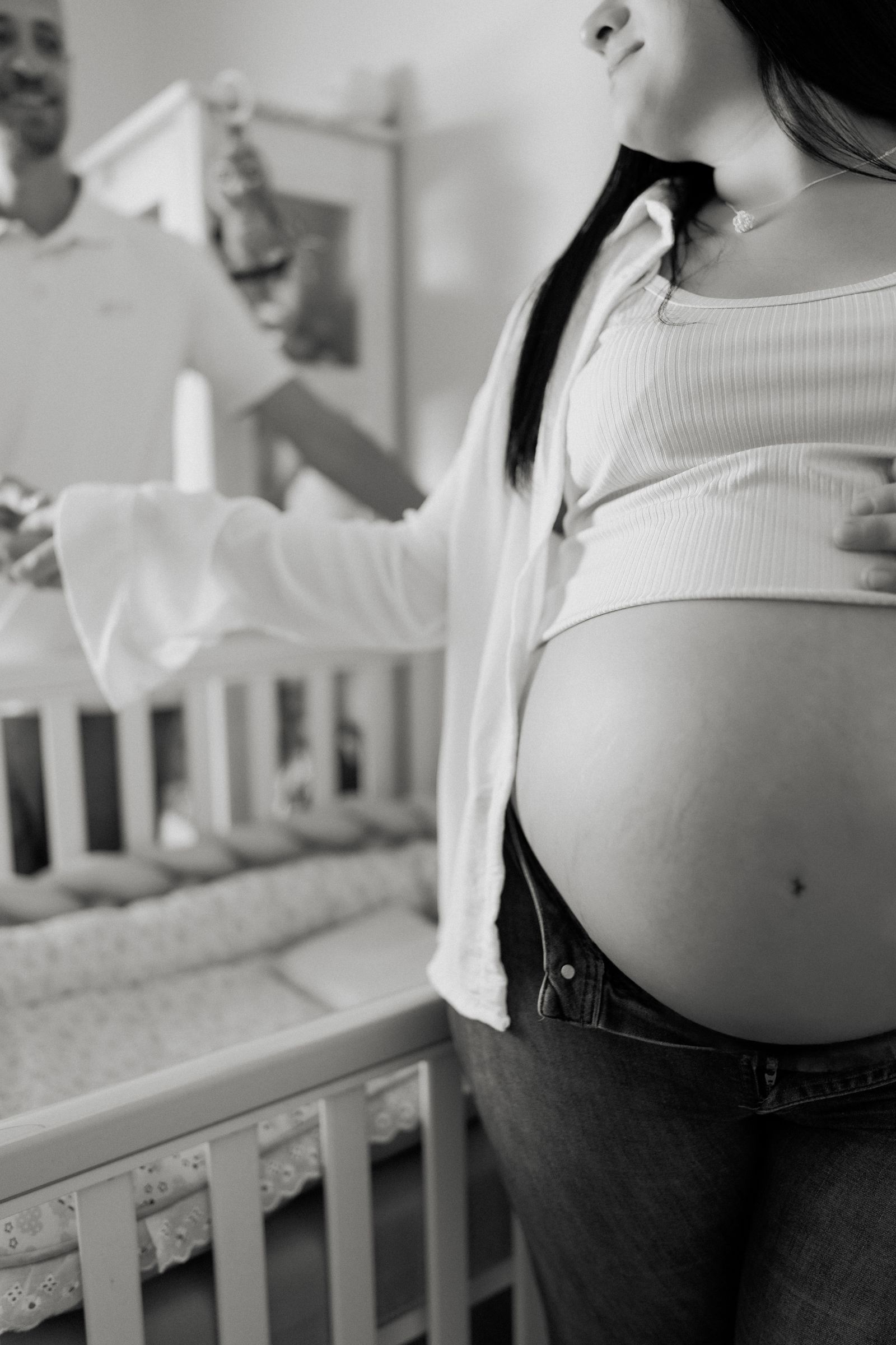 Expectant parents beside a cot in a nursery