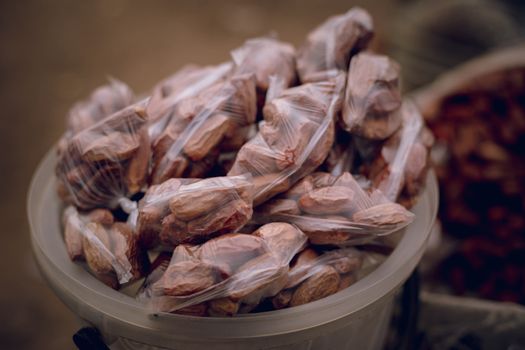 Close-up of plastic bags filled with dried dates at a market, showcasing local food packaging.