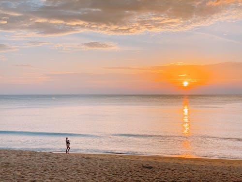 2 Mensen Lopen Op Het Strand Tijdens Zonsondergang