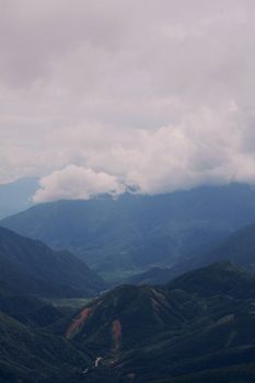 Captivating view of a lush mountain range shrouded in clouds, evoking serenity and natural beauty.
