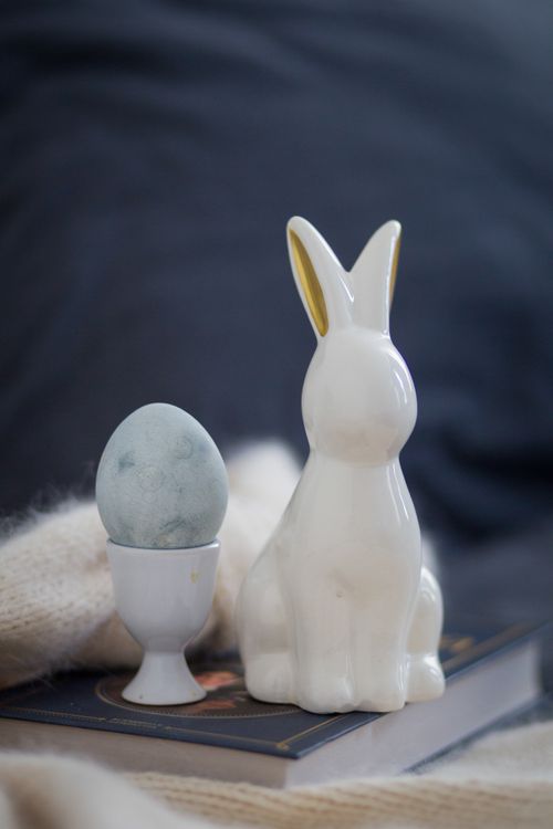 Free Ceramic rabbit with blue Easter egg in soft setting. Perfect for holiday decor. Stock Photo
