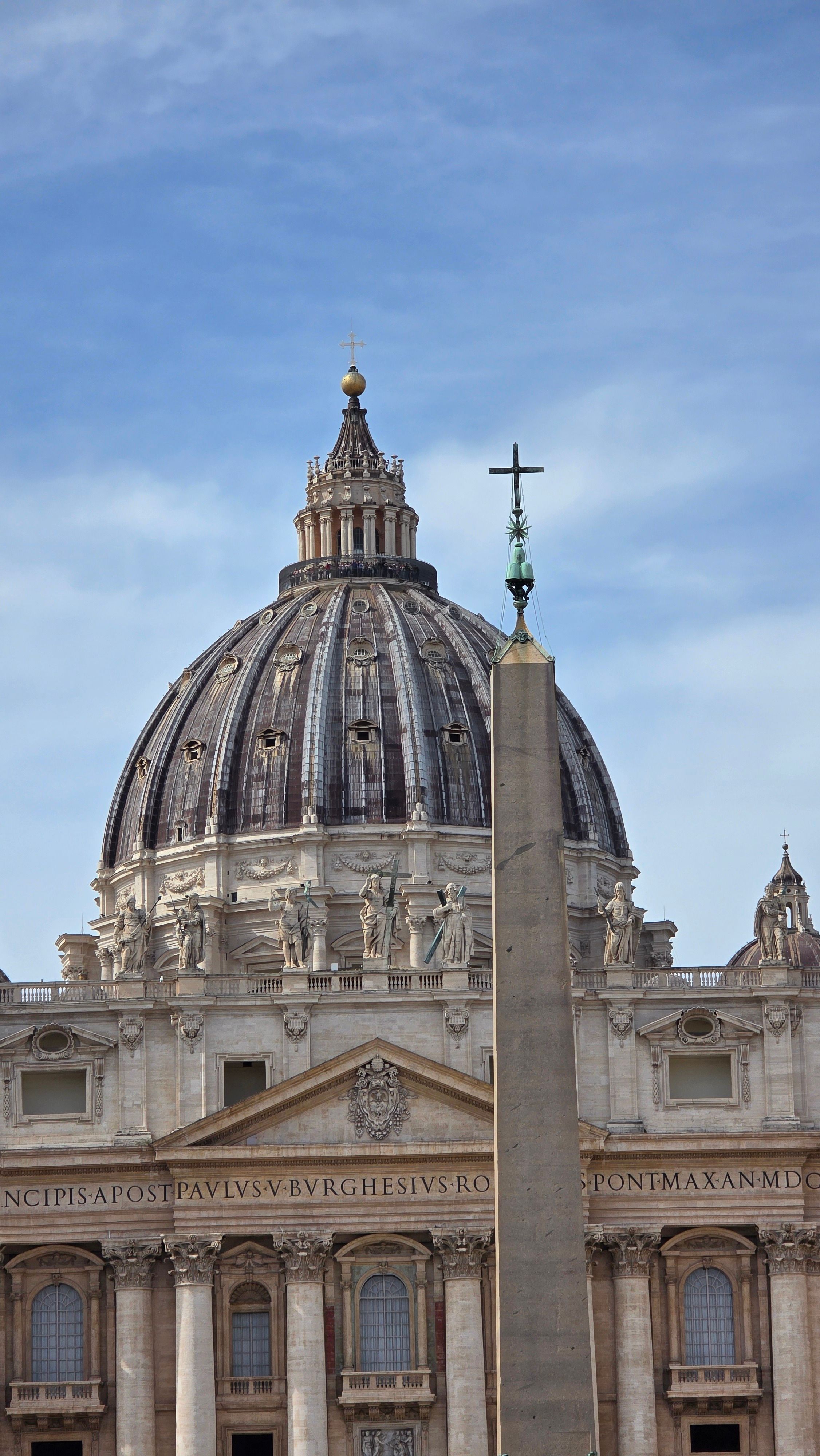 Uitzicht op de koepel van de Sint-Pietersbasiliek en de Vaticaanse obelisk onder een heldere hemel in Rome, Italië.