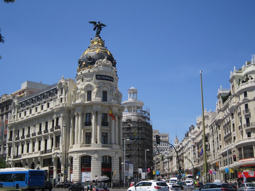 Impresionante vista de la calle del emblemático edificio Metrópolis en Madrid, España, bajo un cielo despejado de verano.