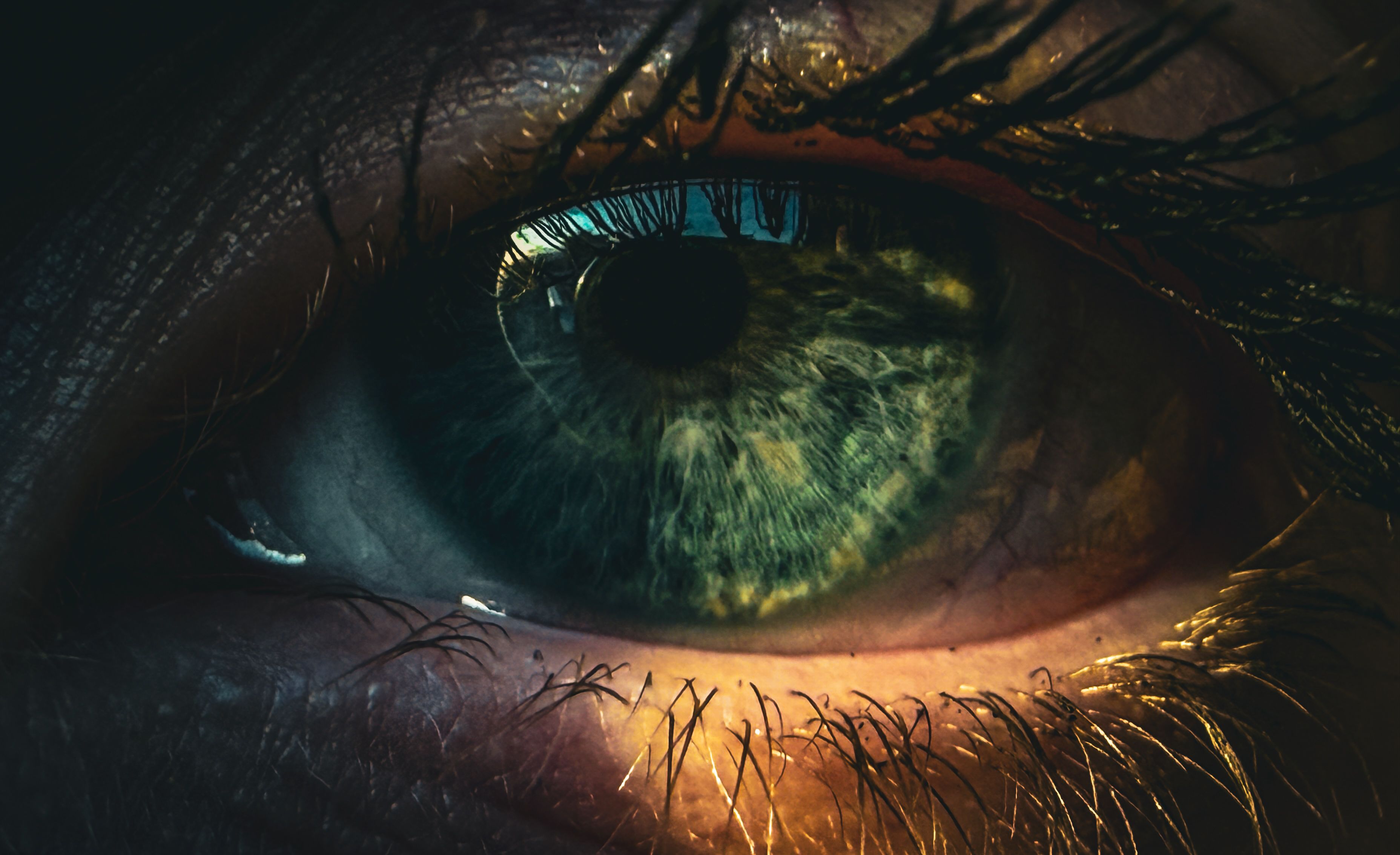 Dramatic close-up photo of an eye with reflections and vivid colors. Captures the intricacy of the iris.