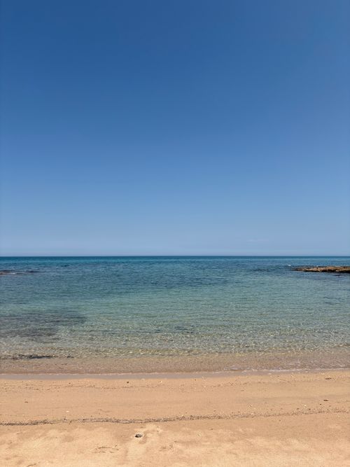 Free A serene beach scene with crystal clear water and bright blue sky, perfect for relaxation. Stock Photo