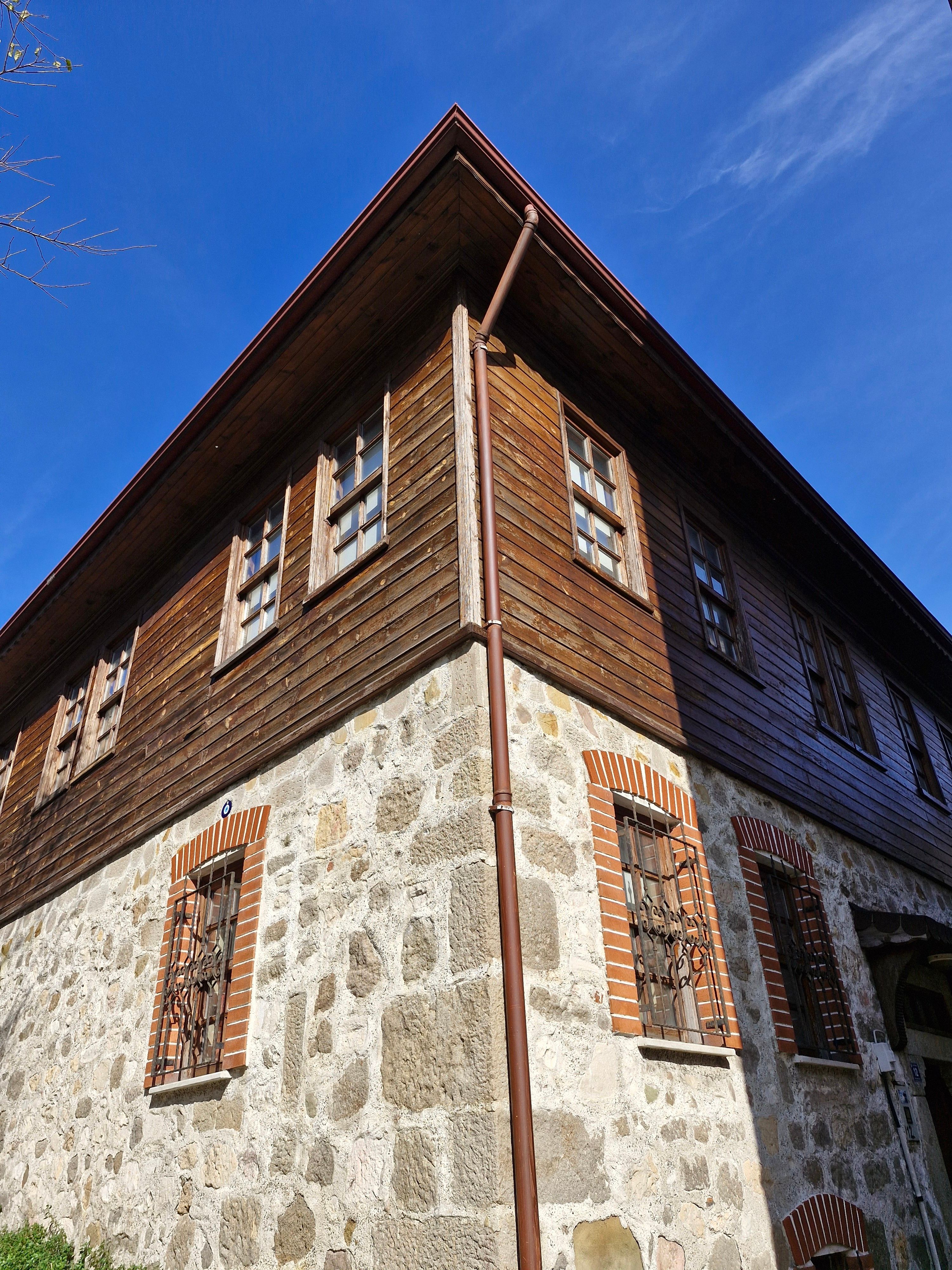 A rustic stone and wood house with clear blue skies, showcasing traditional architecture.