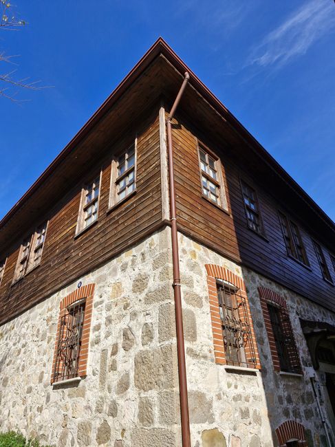 A rustic stone and wood house with clear blue skies, showcasing traditional architecture.