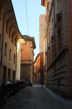 Narrow street in Bologna, Italy with historic architecture and moody lighting.