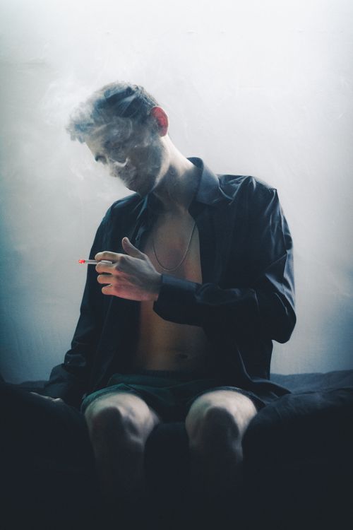 Free Artistic photo of a man in a smoky room with dramatic lighting and shadows. Stock Photo