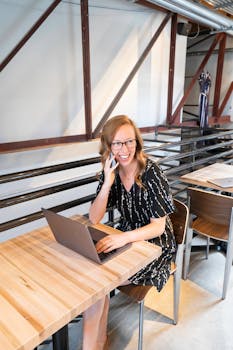 丹佛一家时尚的咖啡馆里，一位开朗的女士正用笔记本电脑和智能手机处理多项任务