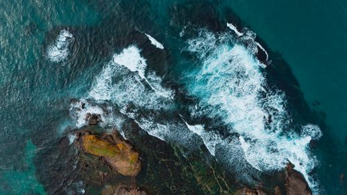 Free Stunning aerial view of waves crashing against a rocky coastline, showcasing the dynamic beauty of nature. Stock Photo