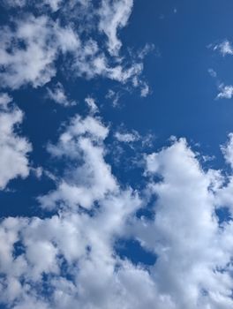 A serene blue sky filled with wispy white clouds, capturing a peaceful and natural atmosphere.