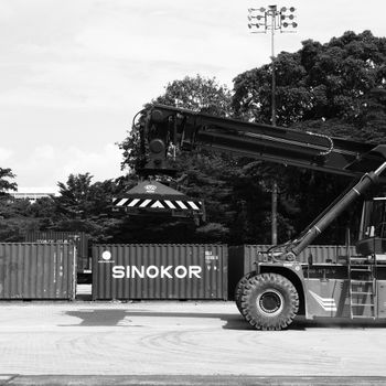Black and white photo of an industrial crane loading shipping containers in Ipoh, Malaysia.