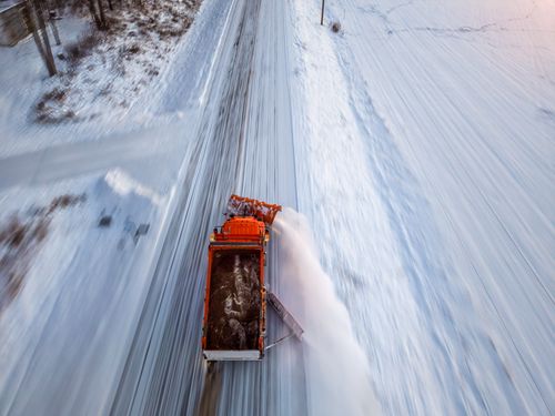 Free An orange snowplow clears a snow-covered road in Kellogg, Minnesota during winter. Stock Photo