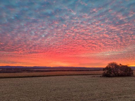 Captivating sunset with vibrant clouds over a rural landscape in Kellogg, Minnesota.