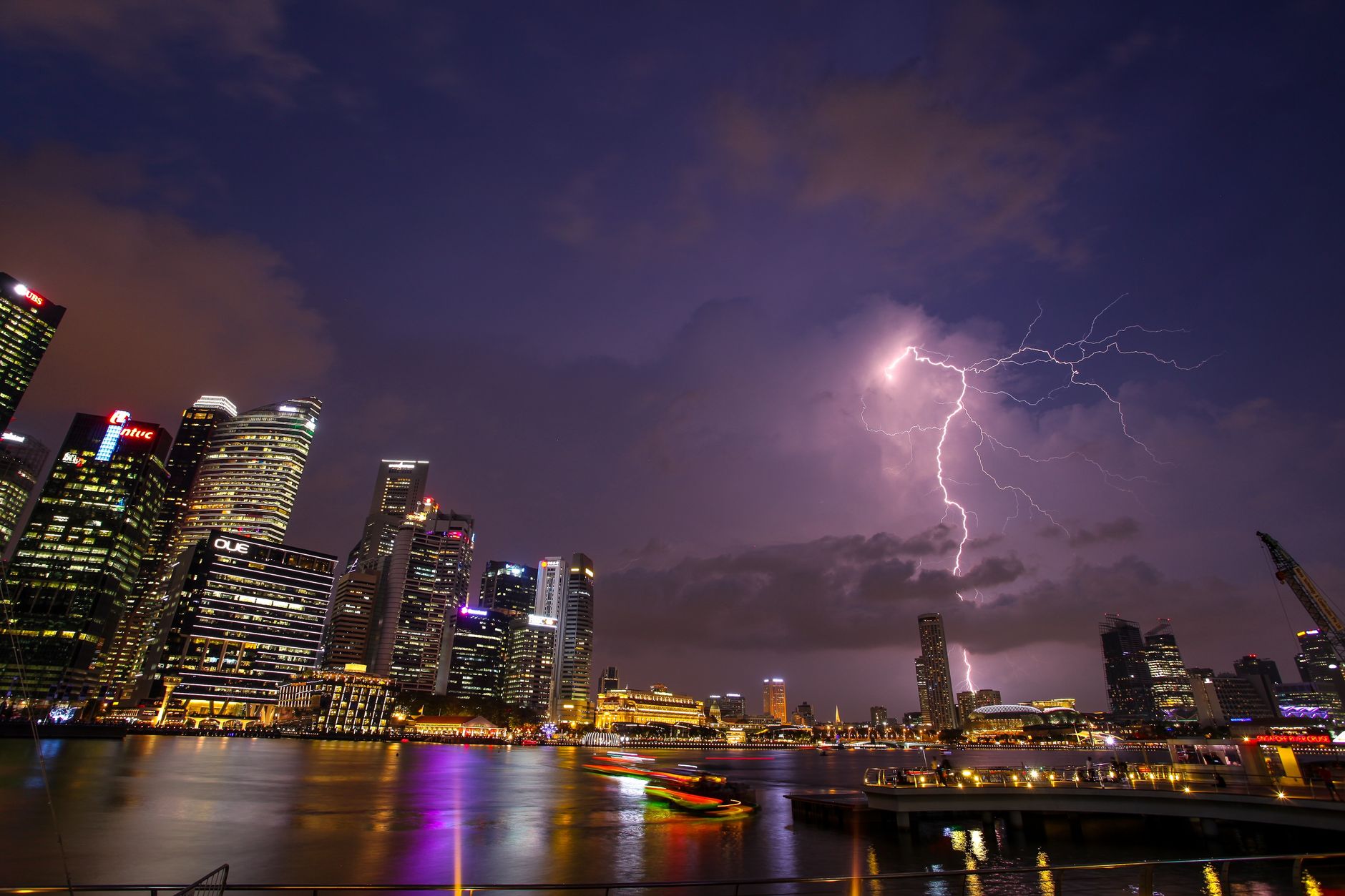 A stunning urban skyline at night with a striking lightning bolt illuminating the cityscape.