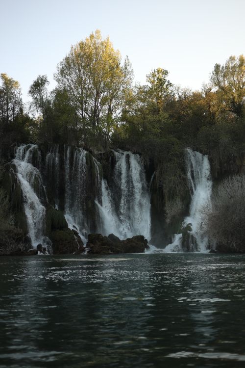 Free A peaceful waterfall cascading amidst lush greenery, offering a serene natural scene. Stock Photo