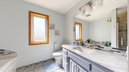 Free Spacious bathroom featuring a marble vanity, large mirror, and bright lighting. Stock Photo