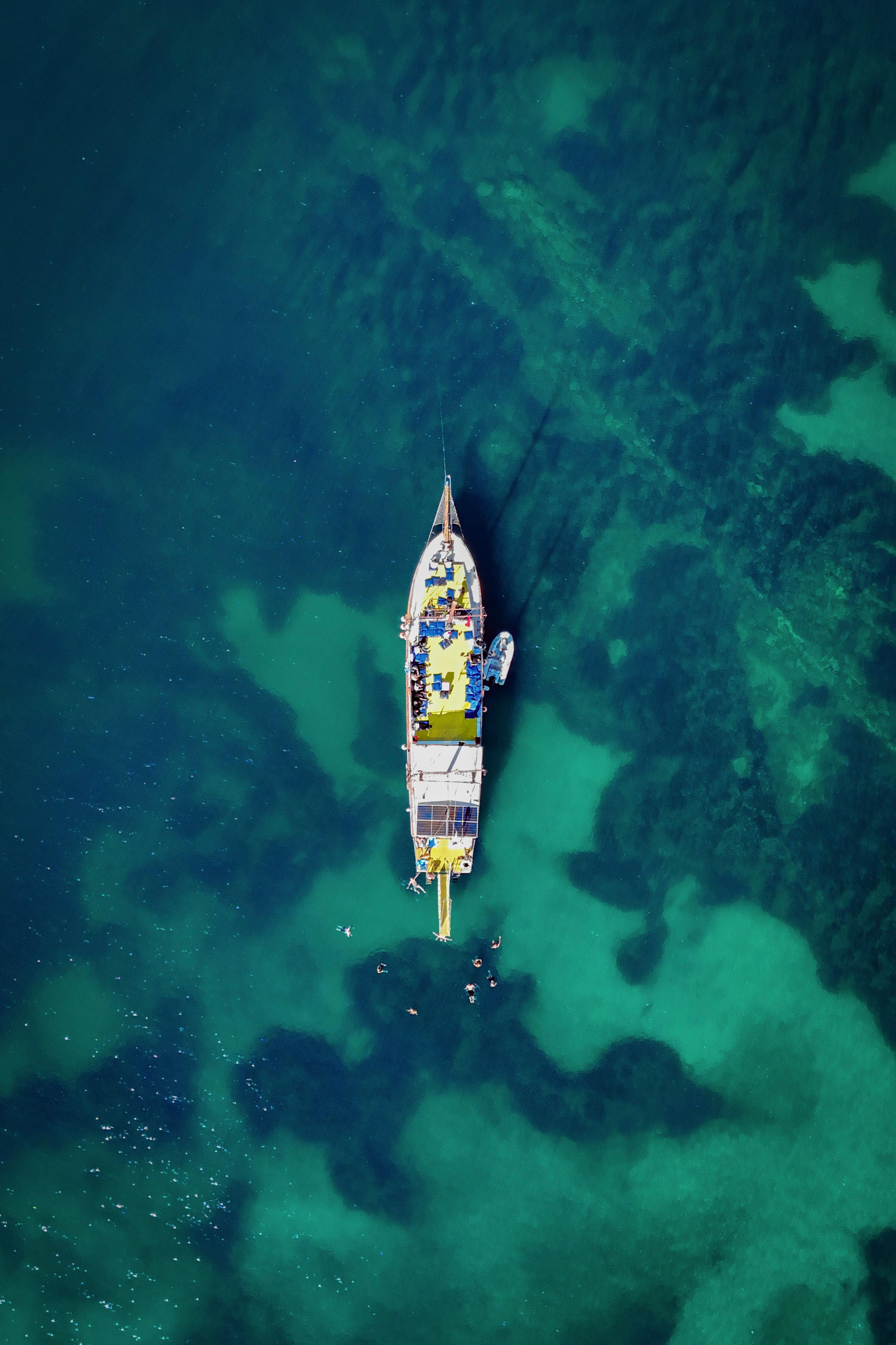 Aerial shot of a boat in the clear turquoise waters near Kuşadası, Türkiye.