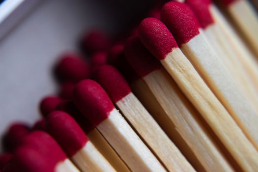 A detailed macro shot of red matchsticks lined up in a box, focusing on texture and color.