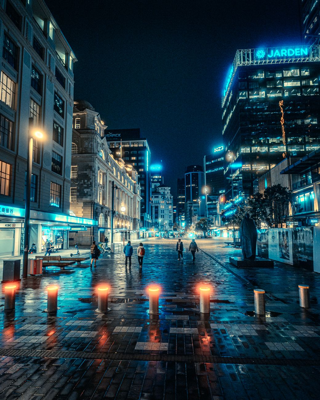 Capture of illuminated city street in Auckland at night with neon lights and modern architecture.