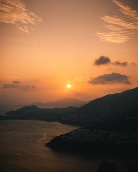 A breathtaking sunset view over a coastal town with silhouetted hills.