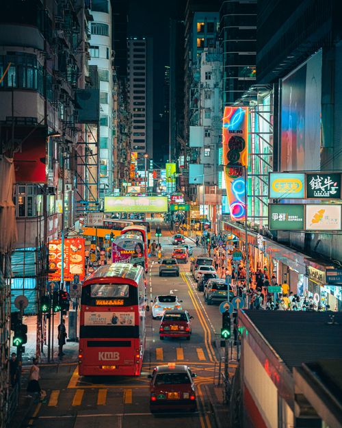 Free A bustling Hong Kong street at night with neon signs, traffic, and vibrant city life. Stock Photo