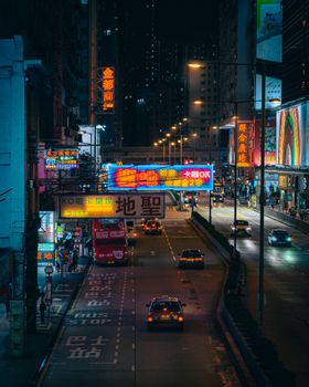 Colorful cityscape of Hong Kong at night filled with neon signs and traffic.