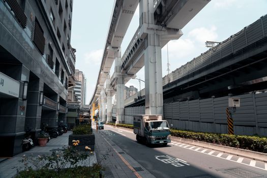 Modern street view featuring a truck under elevated highways in New Taipei City, Taiwan.