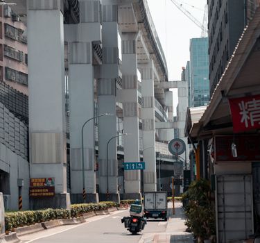 Busy street under elevated highway in New Taipei City, Taiwan, showcasing urban infrastructure.