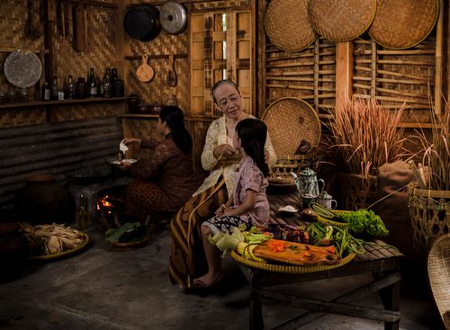 Free A family in a traditional Indonesian kitchen preparing food, highlighting cultural heritage. Stock Photo