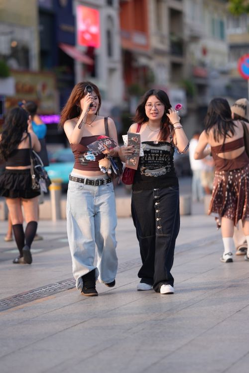 Free Two young women enjoying a casual walk on a busy urban street during the day. Stock Photo