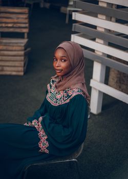 A young woman in traditional attire posing indoors with a serene expression.