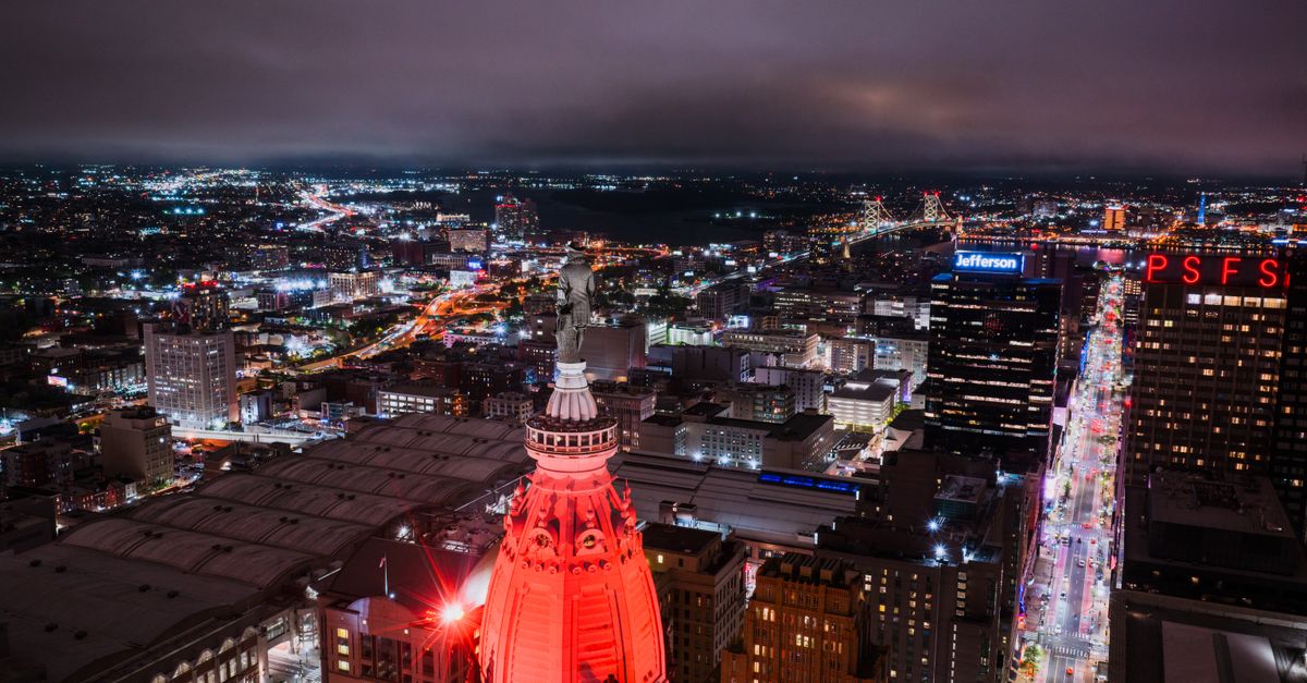 Stunning aerial view of Philadelphia skyline at night showcasing bright city lights and landmarks.